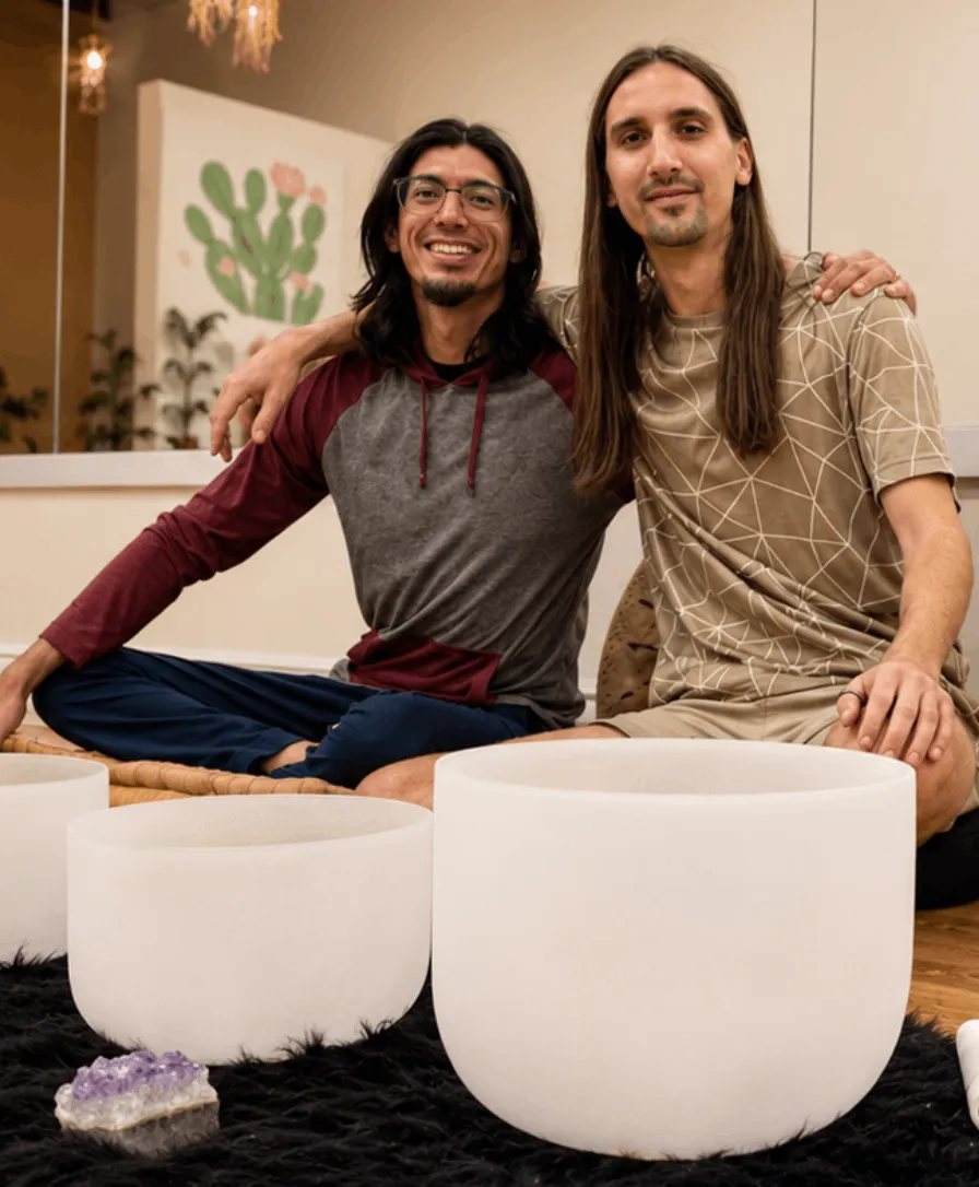 Hunter Plaza and Seth Chapman seated with crystal singing bowls