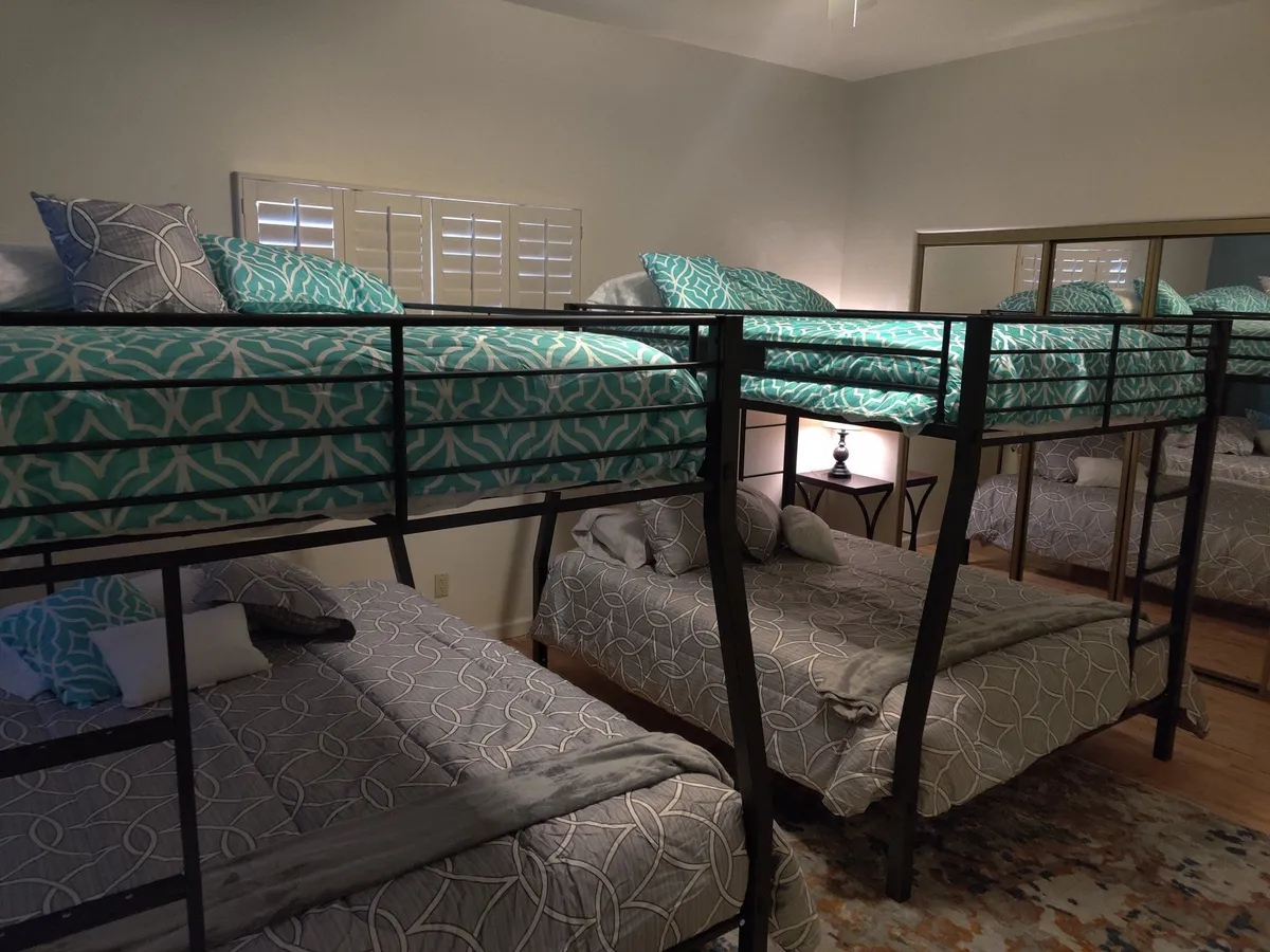 The Peace Room: two metal bunk beds with teal bedding in bright light