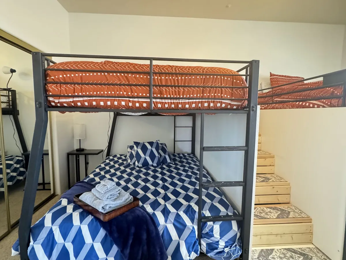 The Tranquility Room: a loft bed with blue patterned bedding beside the stairs up to it
