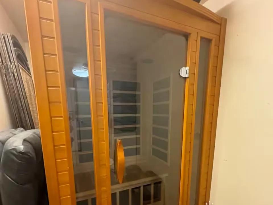 The infrared sauna: a wooden two-person cabin with a glass door